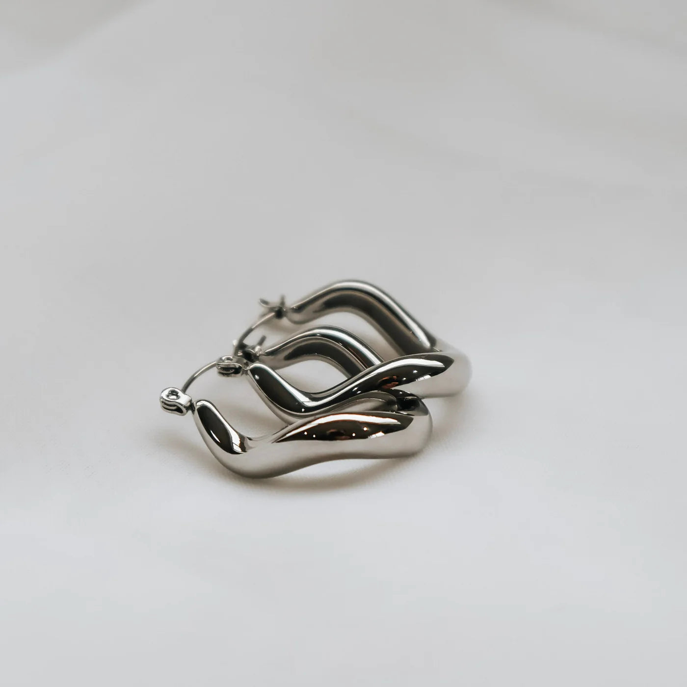 Silver hoop earrings on a light gray background
